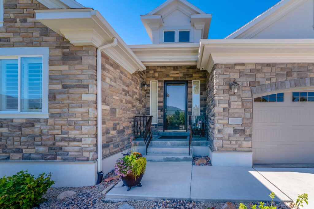 The front entrance to a stone house with a storm door.