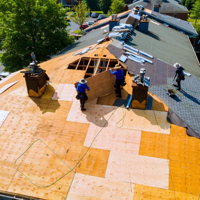 Roofers putting a new roof on a building.